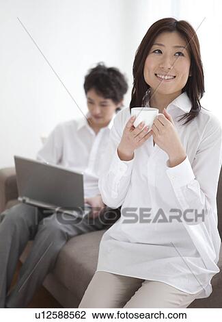 Woman drinking coffee and man using laptop View Large Photo Image Stock Image - Woman drinking coffee and man using laptop. Fotosearch