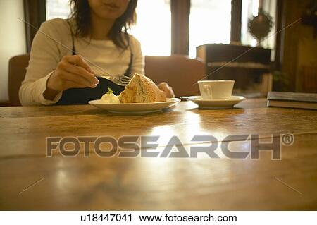 Stock Image - Woman Holding Fork Eating Cake Coffee Cup. Fotosearch