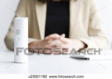 Stock Image - Woman sitting at desk. Fotosearch