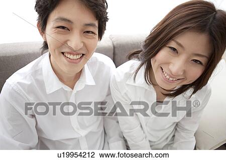 Young couple looking at camera smiling View Large Photo Image Stock Image - Young couple looking at camera smiling. Fotosearch