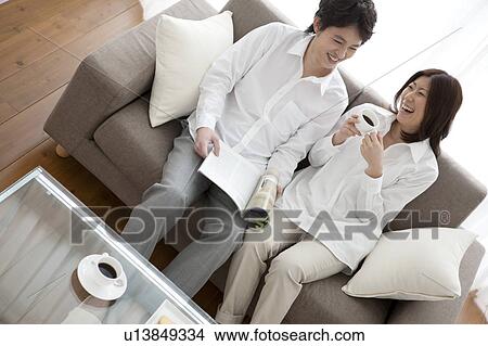 Picture - Young couple relaxing on sofa. Fotosearch