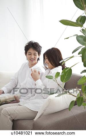 Young couple relaxing on sofa View Large Photo Image Stock Image - Young couple relaxing on sofa. Fotosearch