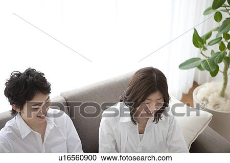 Young couple relaxing on sofa View Large Photo Image Stock Image - Young couple relaxing on sofa. Fotosearch