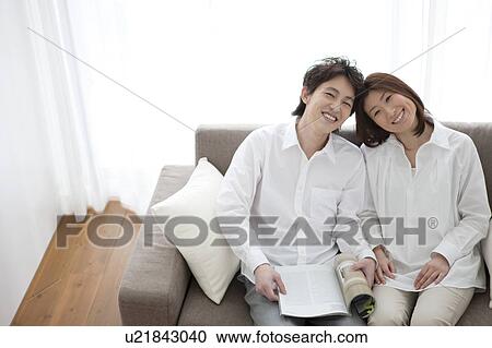 Young couple relaxing on sofa View Large Photo Image Stock Image - Young couple relaxing on sofa. Fotosearch
