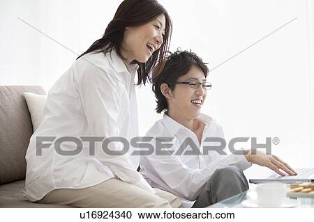 Stock Image - Young couple using laptop. Fotosearch