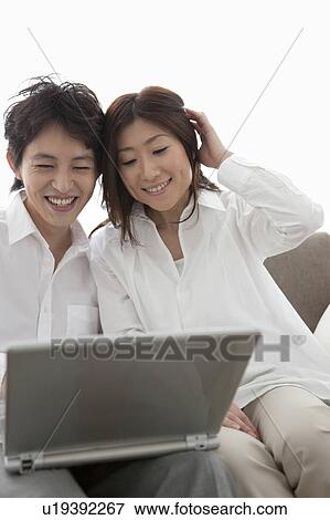 Young couple using laptop View Large Photo Image Stock Photo - Young couple using laptop. Fotosearch