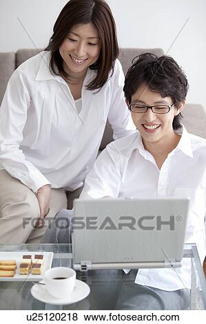 Stock Photo - Young couple using laptop. Fotosearch