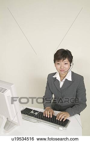Stock Photograph - Young Female Customer Service Represententative Workingr. Fotosearch