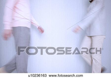 Stock Image - Young man and woman walking, midsection. Fotosearch