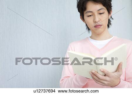 Picture - Young man reading a book. Fotosearch