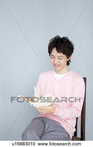 Stock Image - Young man reading a book. Fotosearch