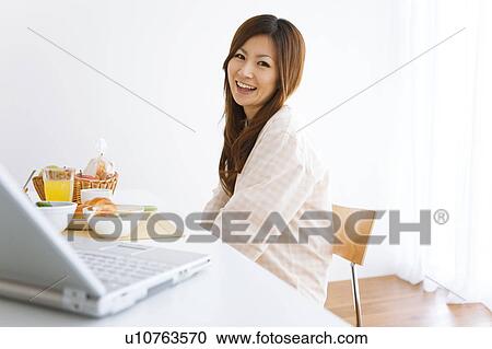 Young woman in pajamas sitting at table View Large Photo Image Stock Image - Young woman in pajamas sitting at table. Fotosearch
