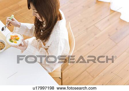 Young woman in pajamas standing and eating breakfast View Large Photo Image Stock Photo - Young woman in pajamas standing and eating breakfast. Fotosearch