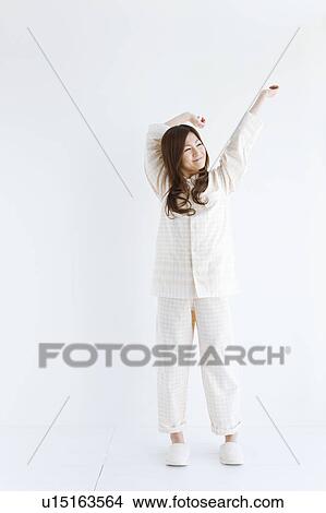 Young woman in pajamas stretching View Large Photo Image Picture - Young woman in pajamas stretching. Fotosearch