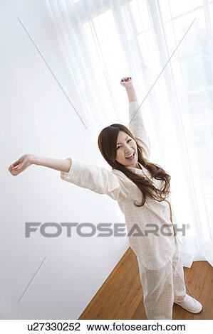 Young woman in pajamas stretching View Large Photo Image Stock Image - Young woman in pajamas stretching. Fotosearch