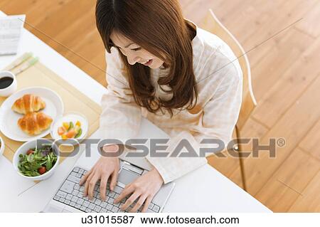 Young woman in pajamas using laptop View Large Photo Image Stock Photo - Young woman in pajamas using laptop. Fotosearch