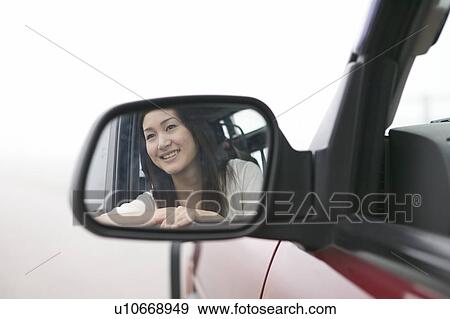 Stock Photo - Young Woman Reflected in Car Mirror. Fotosearch