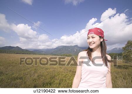 Stock Image - Young Woman with Mountains in Background. Fotosearch