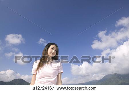 Stock Photo - Young Woman With Mountains in Background. Fotosearch