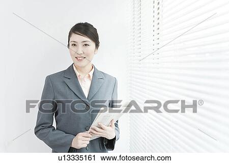 A business woman standing by windows View Large Photo Image Stock Image - A business woman standing by windows. Fotosearch