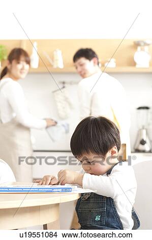 Boy drawing and parents washing dishes View Large Photo Image Picture - Boy drawing and parents washing dishes. Fotosearch