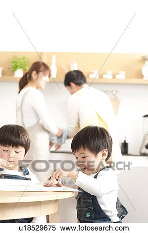 Stock Photography - Brothers drawing and parents washing dishes. Fotosearch
