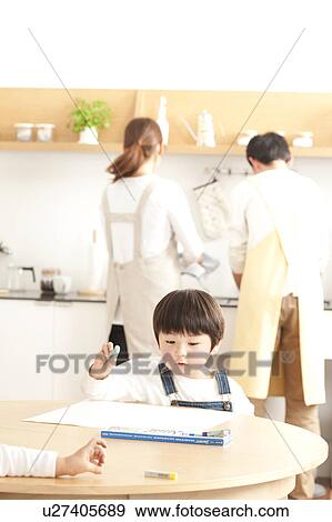Brothers holding crayon and parents washing dishes View Large Photo Image Stock Photo - Brothers holding crayon and parents washing dishes. Fotosearch