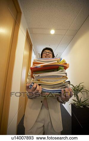 Stock Image - Businessman carrying files. Fotosearch