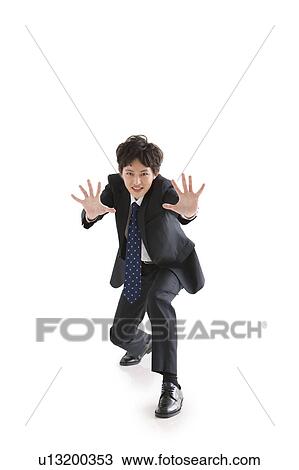 Stock Image - Businessman crouching as if he's pushing something. Fotosearch