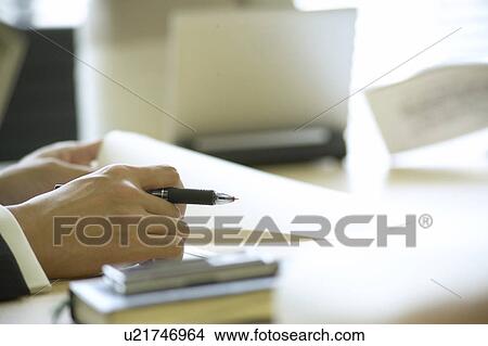 Picture - Businessman holding pen and document. Fotosearch