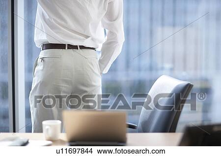 Picture - Businessman looking out the window. Fotosearch