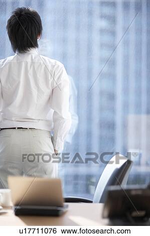 Businessman looking out the window View Large Photo Image Stock Photograph - Businessman looking out the window. Fotosearch