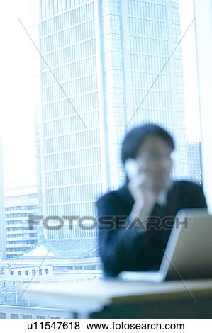 Stock Photo - Businessman sitting in an office, Tokyo Prefecture, Honshu, Japan. Fotosearch