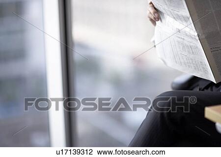 Stock Image - Businessman sitting on chair, midsection. Fotosearch