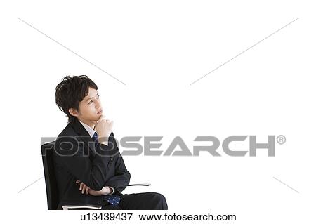 Stock Photo - Businessman sitting on chair contemplating. Fotosearch