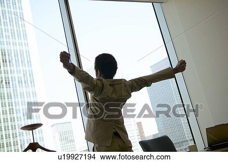 Picture - Businessman stretching in the office. Fotosearch