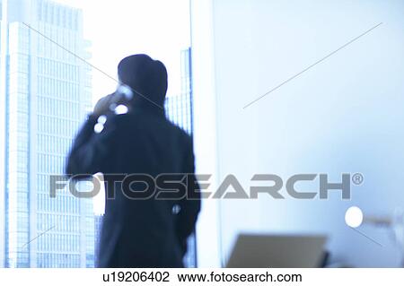 Stock Image - Businessman using a mobile phone, Tokyo Prefecture, Honshu, Japan. Fotosearch