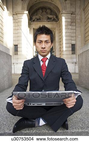 Picture - Businessman Using Laptop on Steps of Royal Exchange. Fotosearch
