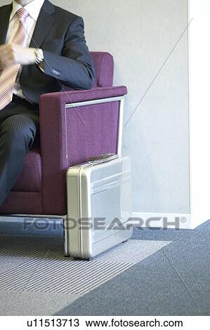 Stock Image - Businessman waiting at reception area. Fotosearch