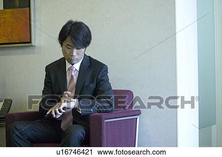 Stock Image - Businessman waiting at reception area. Fotosearch