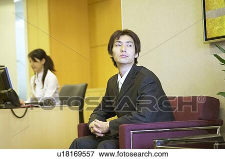 Stock Photo - Businessman waiting at reception area. Fotosearch