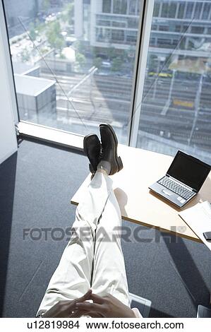 Picture - Businessman with feet up on desk. Fotosearch