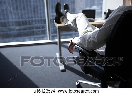 Picture - Businessman with feet up on desk. Fotosearch