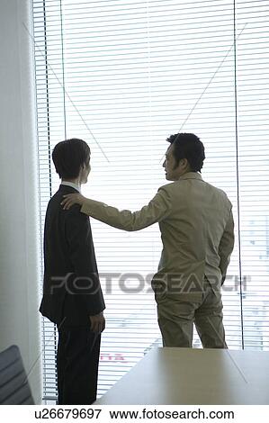 Stock Photo - Businessmen talking by the window. Fotosearch