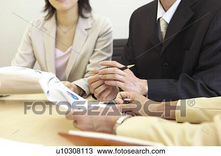 Stock Image - Businesspeople having a meeting. Fotosearch