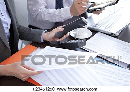 Stock Image - Businesspeople having a meeting. Fotosearch