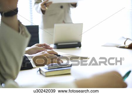 Stock Photo - Businesspeople having a meeting. Fotosearch