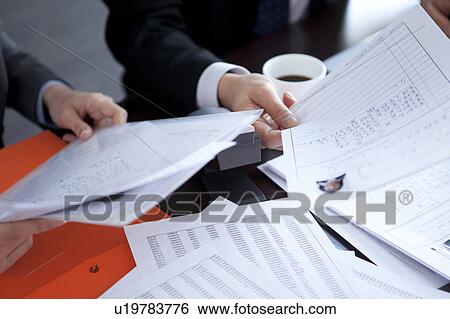 Stock Photograph - Businesspeople looking at resumes. Fotosearch