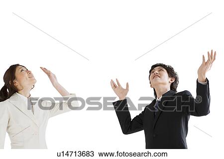 Stock Image - Businesspeople looking up with arms raised. Fotosearch