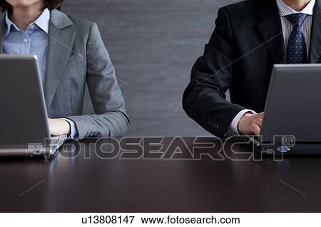 Stock Photo - Businesspeople using laptop. Fotosearch